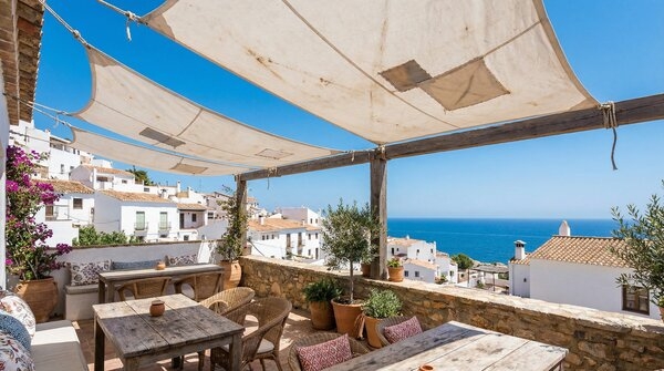 Shade sail structure made from recovered sail cloth over outdoor seating